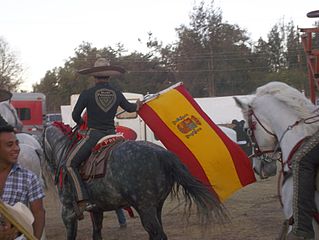 Charro a caballo con la bandera de España